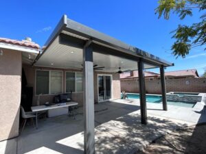 Covered patio with aluminum awnings overlooking a pool in a backyard in Indio, CA.