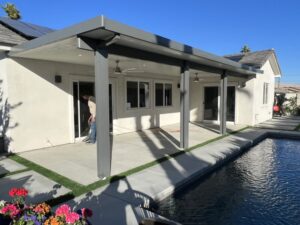 A beautiful pool with a covered patio, highlighting wooden and vinyl patio covers in Indio, California.