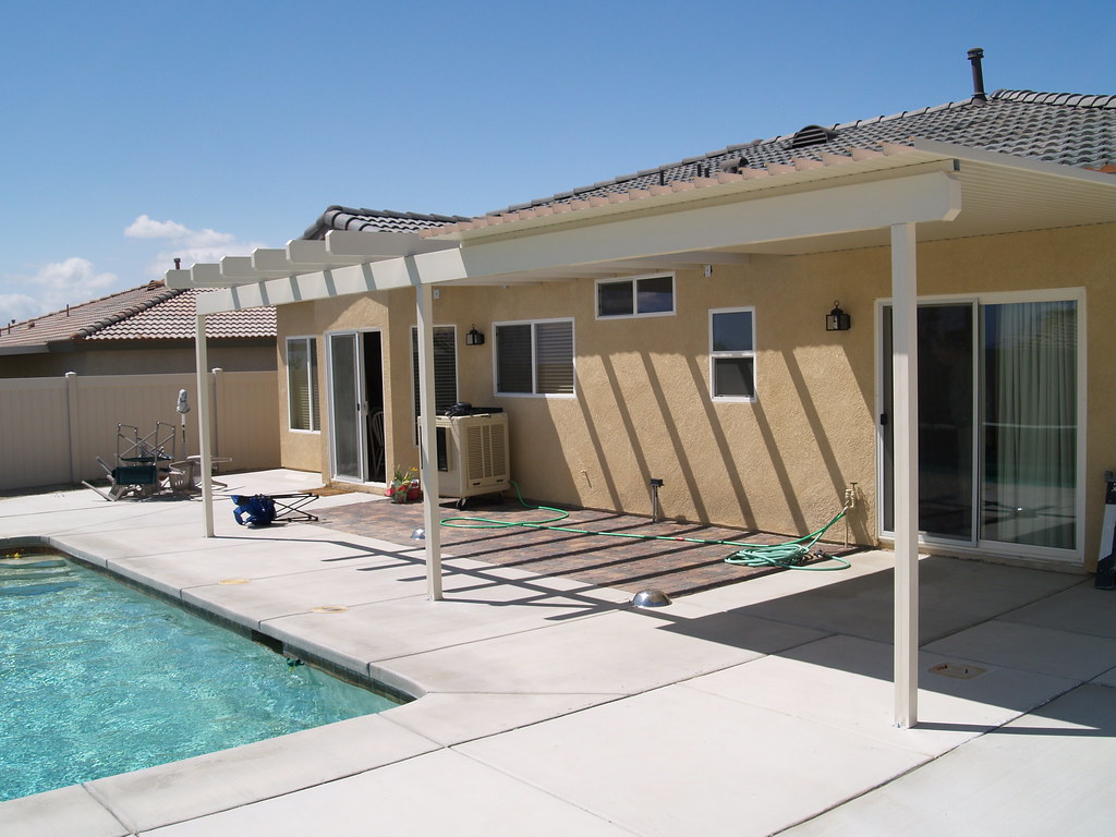A refreshing pool surrounded by an Alumawood patio cover in a backyard setting, located in Indio, CA.
