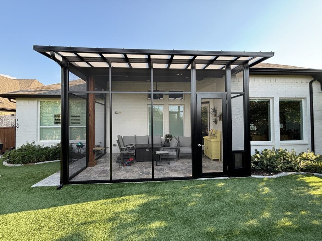 A backyard patio featuring a glass-enclosed porch, ideal for relaxation. Search for aluminum patio covers near me in Indio, CA